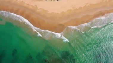 Waves come and go on a beach of Philippines. The lagoon is turquoise with relaxing waves in paradise nature - aerial view with a drone 4K