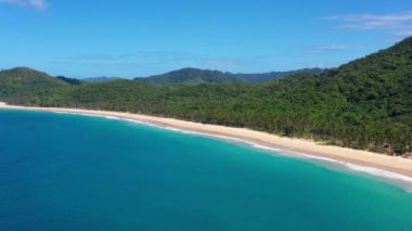 Aerial view of the white-sand beach of El Nido, Philippines. We can see mountains and palm trees forest in the background, perfect for summer travel in nature 4K