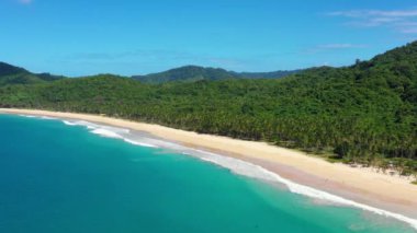 Aerial view of the white-sand beach of El Nido, Philippines. We can see mountains and palm trees forest in the background, perfect for summer travel in nature 4K