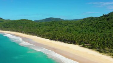 Aerial view of the white-sand beach of El Nido, Philippines. We can see mountains and palm trees forest in the background, perfect for summer travel in nature 4K