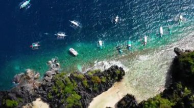 Filipinler, El Nido 'daki Gizli Göl' ün ortasındaki tekneler. Seyahat ve cennet için mükemmel bir tatil. Güneşin altındaki yaz tatili. 4K dronlu hava manzaralı.