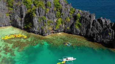 Boats in the middle of the Small Lagoon in El Nido, Philippines. Perfect leisure for travel and paradise summer holidays under the sun - aerial view with a drone 4K