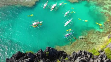 Boats in the middle of the Small Lagoon in El Nido, Philippines. Perfect leisure for travel and paradise summer holidays under the sun - aerial view with a drone 4K