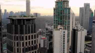 Turuncu bir günbatımının altında Manila silueti. Filipinlerin güzel başkenti sisle kaplıydı. Ufukta sadece şehrin binalarını görebiliyoruz.