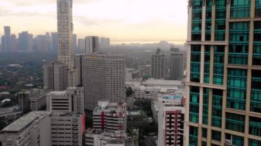 Turuncu bir günbatımının altında Manila silueti. Filipinlerin güzel başkenti sisle kaplıydı. Ufukta sadece şehrin binalarını görebiliyoruz.