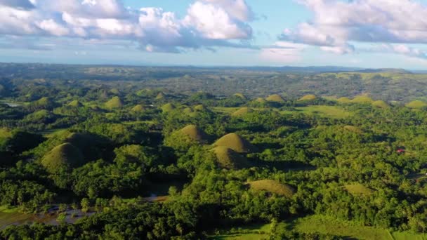 フィリピンのボホールのチョコレートヒルズの上にドローンでパノラマビュー 青い空の下 地平線の至る所に美しい緑の丘と木々 — ストック動画