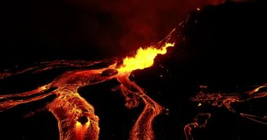 Wide shot taken by helicopter of fagradalsfjall volcano.. Wide view of fagradalsfjall volcano. The shot taken by helicopter at midnight shows glowing lava lighting the whole place while flowing under the dark sky of Iceland in a stunning view.
