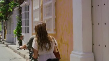 Following shot of a young tourist couple riding chopper motorcycle.