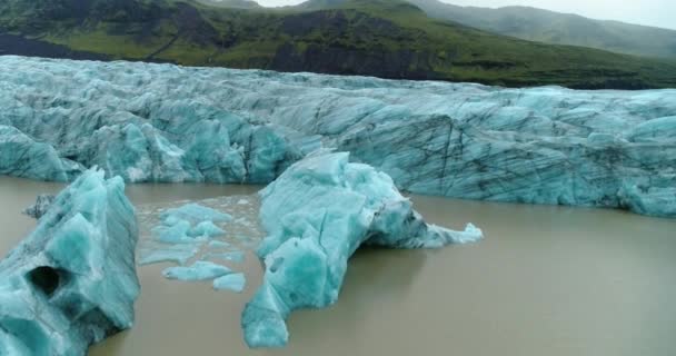 在一个寒冷的冬日拍摄的中景照片显示了冰岛索尔希马约克尔冰川的冰层 在清澈的天空下 青翠的群山映衬在背景上 — 图库视频影像
