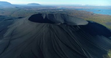 İzlanda 'da aktif olmayan bir Hverfjall volkan kraterinin muhteşem manzarası. Pasif bir Hverfjall yanardağının, İzlanda 'nın doğasının büyüleyici manzarasında dağları ve ormanları çevreleyen muhteşem kuş bakışı görüntüsü.