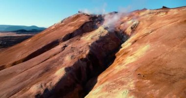 İzlanda 'daki panoramik manzara dağlık arazi ve eteklerdeki göl. Panoramik manzara canlı yeşil tepeler ve tepeler gösteriyor, ve tepeden akan muhteşem suyla küçük bir şelale ve dağ eteklerindeki güzel bir göle dökülüyor..