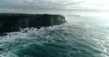 İzlanda 'daki panoramik manzara dağlık arazi ve eteklerdeki göl. Panoramik manzara canlı yeşil tepeler ve tepeler gösteriyor, ve tepeden akan muhteşem suyla küçük bir şelale ve dağ eteklerindeki güzel bir göle dökülüyor..