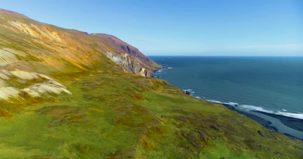 ケチスタディールの東海岸 アイスランドの眺め 緑の平野 山の崖 美しい青い海 澄んだ冷たい空 小さな波が素晴らしい日に海岸線に衝突するのを示す ケチスタディール東海岸での印象的なショット — ストック動画