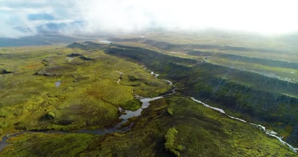 非常に標高の高い緑の山のテラスの空中ビューは ショットは春の日に撮影されたので 山は緑の草で覆われている 小さな川の上から山の雨水ストリーミングの頂上に触れる低雲 — ストック動画