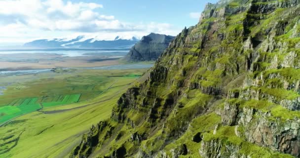 高地のアイスランドのパノラマの風景や丘陵地帯の湖 パノラマの景色は鮮やかな緑の尾根や丘 丘の上を水が流れ 美しい湖に足を踏み入れる小さな滝を示しています — ストック動画
