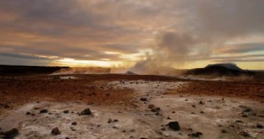 İzlanda dağlarındaki güzel bir şelalenin hava görüntüsü. Nehir, suyu dağın tepesinden onun dibine kadar taşıyor. Dağ yeşil yay çimenleriyle kaplıdır..
