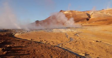 İzlanda 'daki panoramik manzara dağlık arazi ve eteklerdeki göl. Panoramik manzara canlı yeşil tepeler ve tepeler gösteriyor, ve tepeden akan muhteşem suyla küçük bir şelale ve dağ eteklerindeki güzel bir göle dökülüyor..