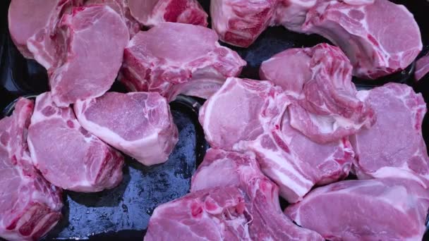 Una vista de un lomo de cerdo fresco y refrigerado acostado en la ventana de una tienda de comestibles. — Vídeos de Stock