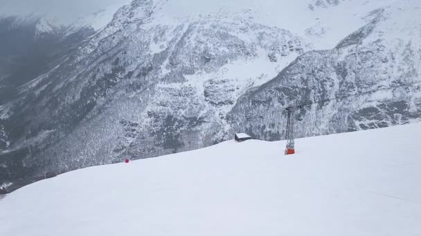 En cámara lenta. Disparos con drones. Vista superior de la pista de esquí de la estación de montaña y el teleférico.. — Vídeos de Stock