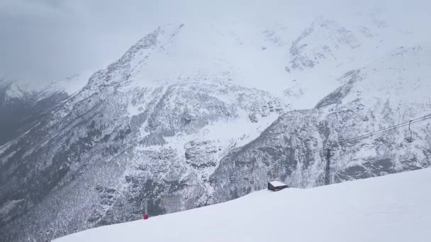 Langzame beweging. Schieten met een drone. Bovenaanzicht op de skipiste van het bergresort en de kabelbaan.. — Stockvideo