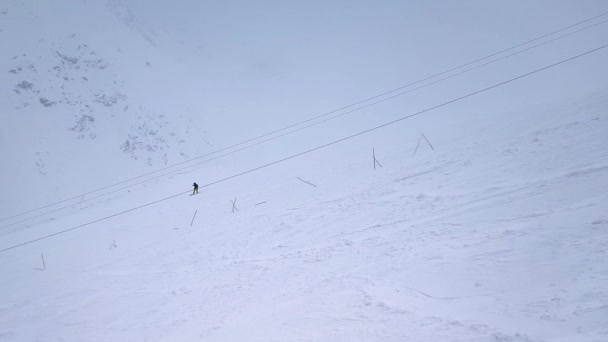 Ağır çekim. İHA saldırısı. Yalnız bir snowboardcunun karlı havada dağ yamacından aşağı inişi... — Stok video