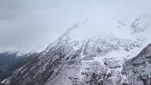 Zeitlupe. Blick von oben auf die schneebedeckten Berghänge und das Tal.. — Stockvideo