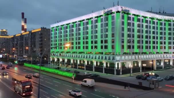 24.11.2021 Moscú. Vista aérea de la carretera con vehículos en movimiento, el hotel Radisson por la noche bajo la luz de farolas en Moscú cerca de la estación de tren Kievsky. — Vídeos de Stock