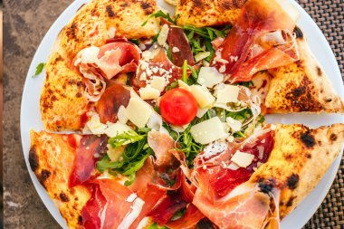 Nefis İtalyan pizzası, prosciutto, roka, taze domates ve tıraş edilmiş parmesan peyniri..