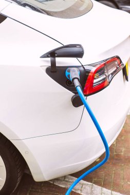 Charging an electric car with the power cable supply plugged into the green station.