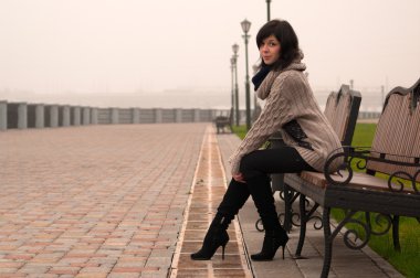 bir bankta oturan siyah saçlı genç güzel kız