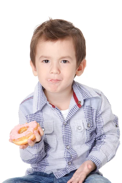 Garçon manger un beignet — Photo
