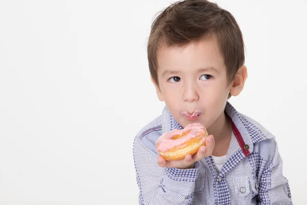 Chico comiendo un donut — Foto de Stock