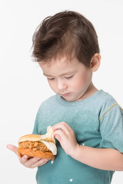 Junge isst einen Burger — Stockfoto