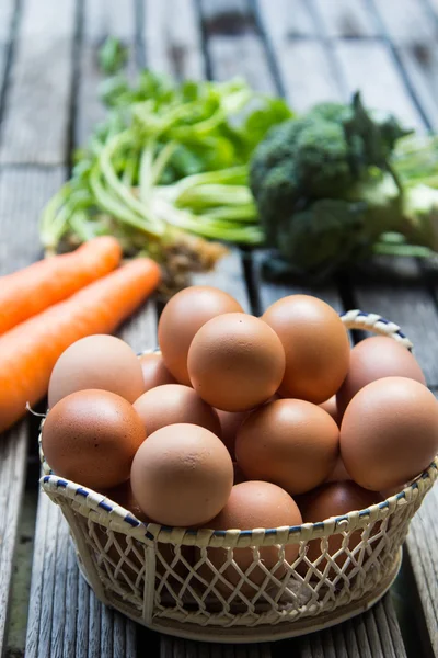 Eggs in basket and vegetables — Stock Photo, Image