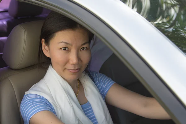 Mujer sonriente sentada en el coche — Foto de Stock