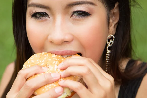 Fille manger un cheeseburger — Photo