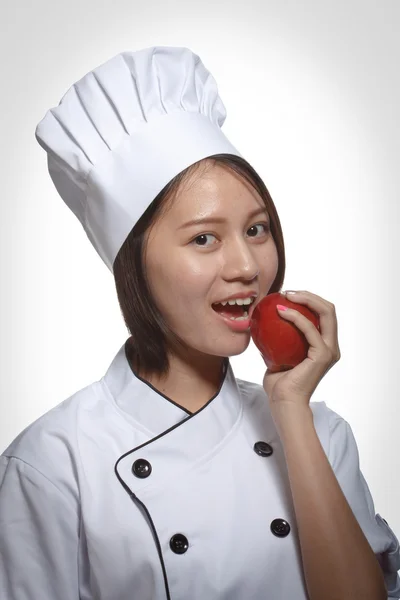 Cook woman eating fruit. — Stock Photo, Image