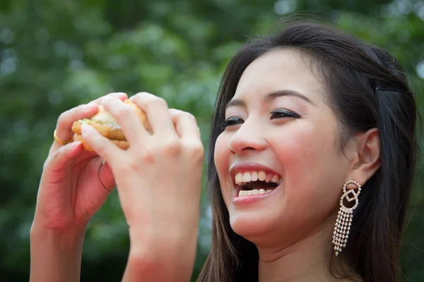 Chica comiendo una hamburguesa con queso — Foto de Stock