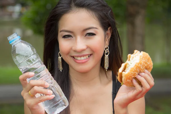 Mladá žena se těší kuřecí burger — Stock fotografie