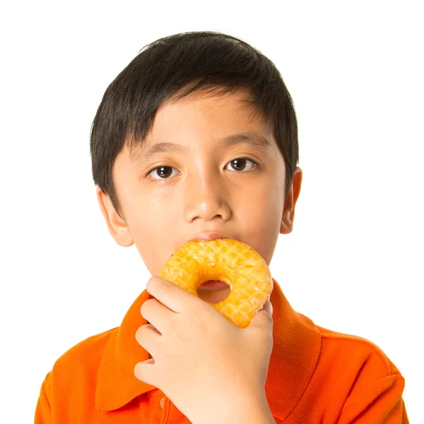 Menino comendo um donut — Fotografia de Stock