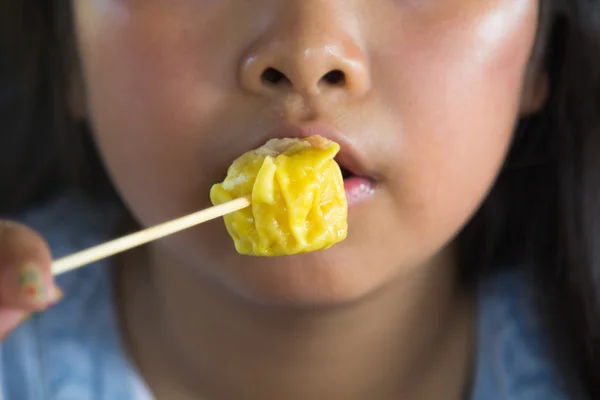 Menina asiática comer bolinhos — Fotografia de Stock