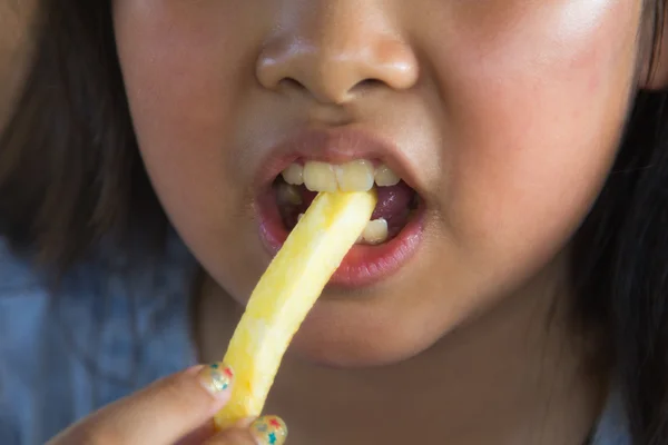 Menina asiática comer batatas fritas — Fotografia de Stock