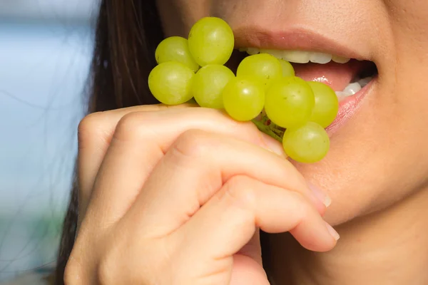 Vrouw eten groene druiven friut — Stockfoto