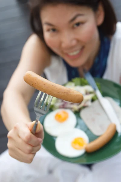 有魅力的女人，给一根香肠 — 图库照片