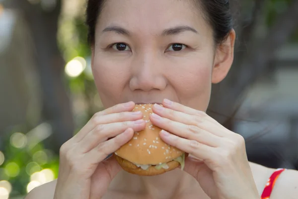 Kobieta jedząca hamburgera — Zdjęcie stockowe