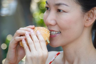 Hamburger yiyen kadın.