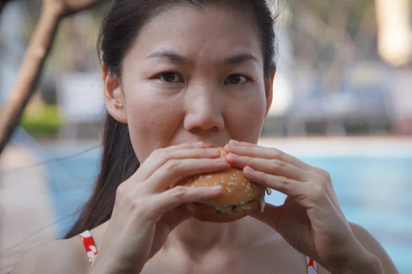 Femme mangeant un hamburger — Photo