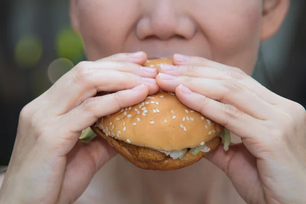 Kobieta jedząca hamburgera — Zdjęcie stockowe