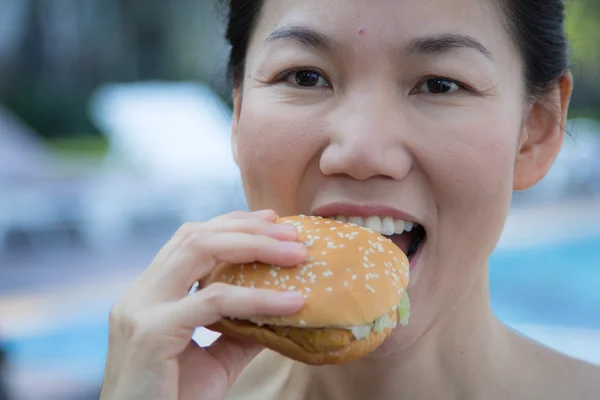 Mulher comendo um hambúrguer — Fotografia de Stock