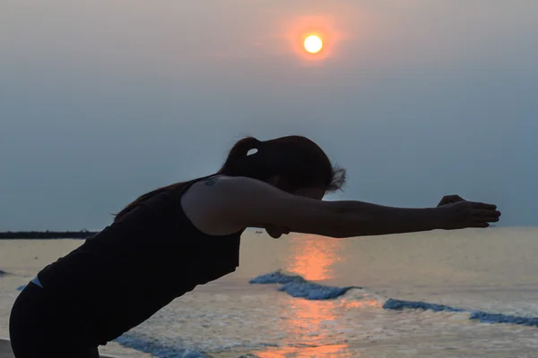 Femme de yoga sur la belle plage au lever du soleil — Photo